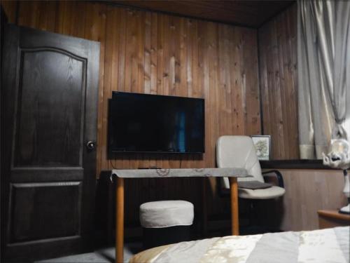 una camera con TV, letto e sedia di Охотничий домик a Almaty