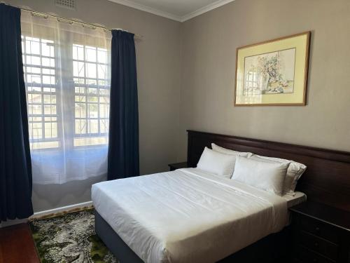 a bedroom with a large bed and a window at Prime Executive Accommodation in Cape Town
