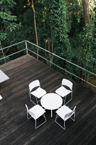 a table and chairs on a wooden deck at Sometimes Khaoyai in Ban Muak Lek Nai