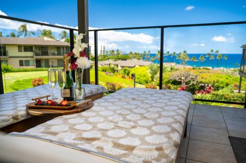 a balcony with a bed and a view of the ocean at Elua 406 in Wailea