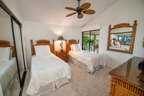 a bedroom with two beds and a mirror at Elua 406 in Wailea