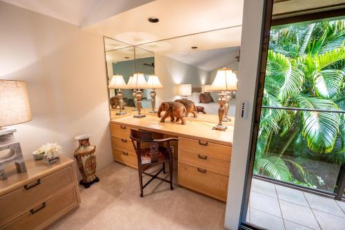 a bathroom with a desk and a mirror at Elua 406 in Wailea