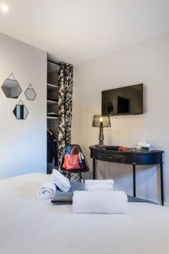 a bedroom with a bed with towels and a desk at Résidences Alticimes in Brides-les-Bains