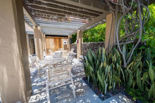 a patio with a table and chairs and plants at Elua 406 in Wailea