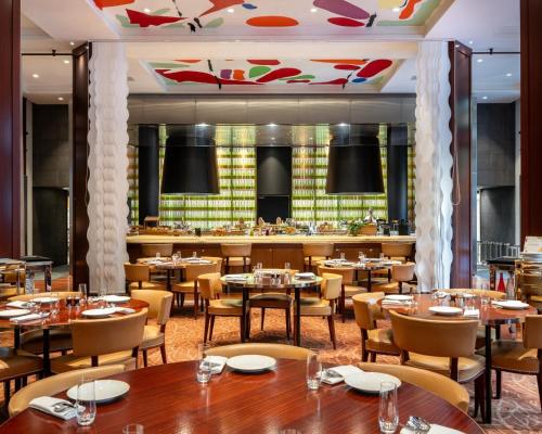 a restaurant with tables and chairs and a bar at Hôtel Le Royal Monceau Raffles Paris in Paris