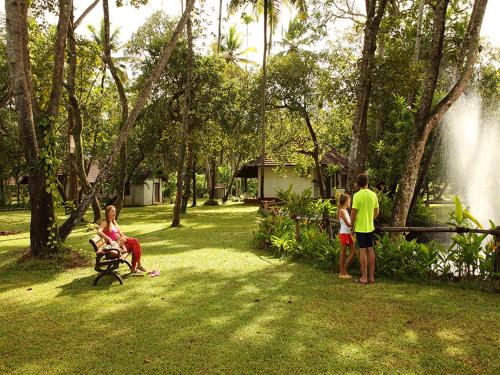 a group of people standing in a park with a fountain at Abad Turtle Beach in Mararikulam