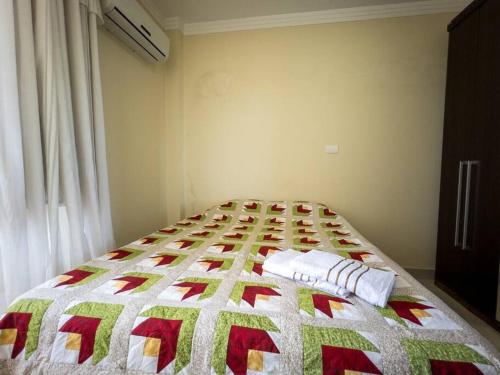 a bedroom with a christmas quilt on a bed at Apartamento perto UEM Wi-Fi MN701 in Maringá
