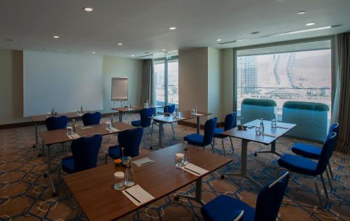 a conference room with tables and blue chairs at Four Points by Sheraton Izmir in Izmir