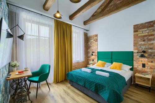 a bedroom with a green bed and a table and a chair at Apartamenty Pod Bocianem in Muszyna