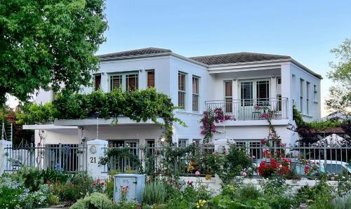 a white house with flowers in front of it at Penelope's Stellenbosch in Stellenbosch