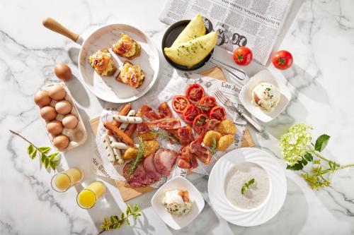 a table topped with plates of food and eggs at Le Meridien Taipei in Taipei