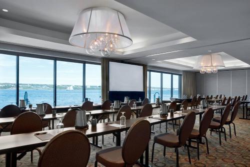 a dining room with tables and chairs and windows at Halifax Marriott Harbourfront Hotel in Halifax