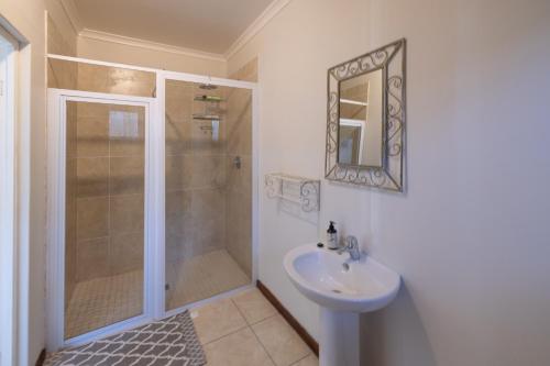 a bathroom with a shower and a sink at Delightfully Casual & Spacious in Cape St Francis