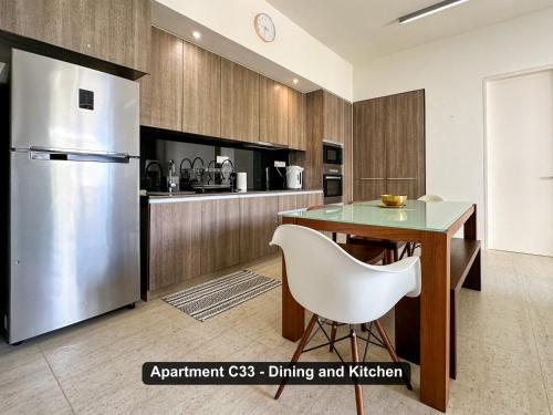 a kitchen with a refrigerator and a table at By the Sea- Pool and Sea View in Batu Ferringhi