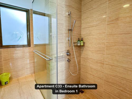 a bathroom with a shower with a glass door at By the Sea- Pool and Sea View in Batu Ferringhi