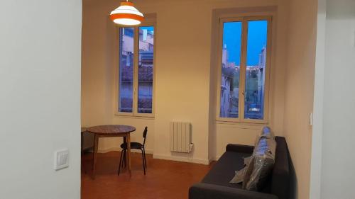 - un salon avec un canapé, une table et des fenêtres dans l'établissement Marseille Longchamp, à Marseille