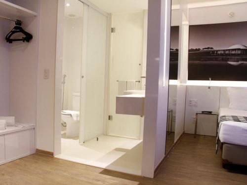 a room with a bathroom with a toilet and a sink at ibis Styles Brasilia Aeroporto in Brasilia