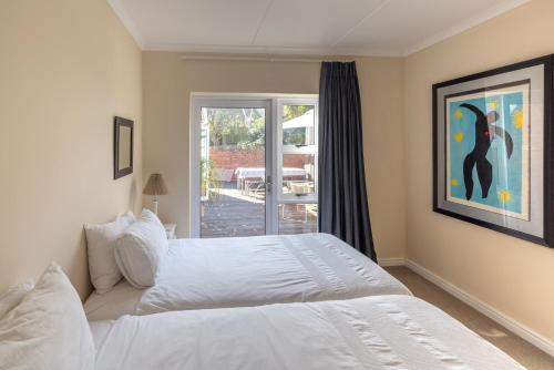 a bedroom with a white bed and a window at Delightfully Casual & Spacious in Cape St Francis