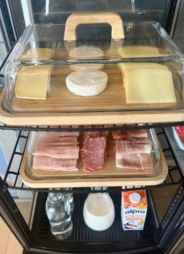 a refrigerator shelf filled with meat and other foods at Le Beau Séjour in Saint-Raphaël