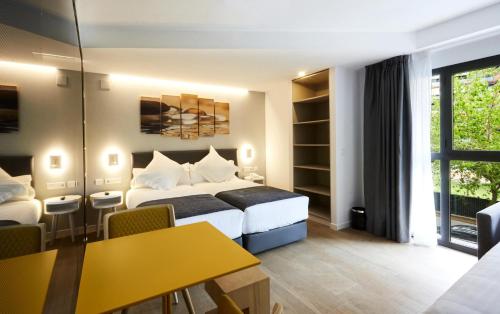 a hotel room with a bed and a yellow table at Sercotel Valencia Alameda 41 in Valencia
