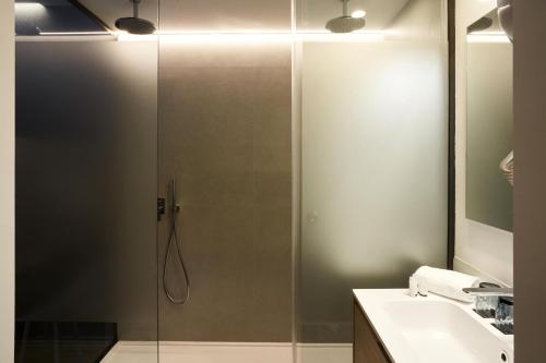 a shower with a glass door in a bathroom at Sercotel Valencia Alameda 41 in Valencia