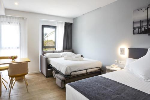 a hotel room with two beds and a desk at Sercotel Valencia Alameda 41 in Valencia