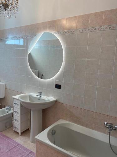 a bathroom with a sink and a tub and a mirror at Residence Corona Grossa Balangero in Balangero