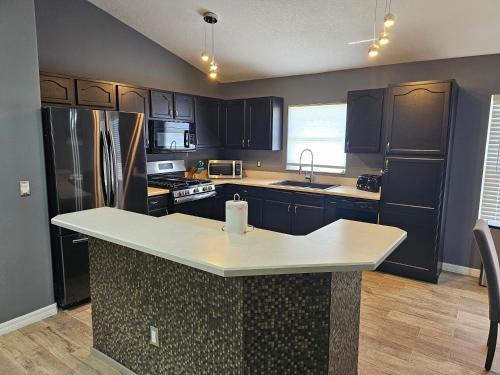a kitchen with black cabinets and a white counter top at Mufasa's Pride in Kissimmee