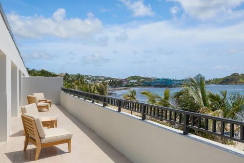 a balcony with chairs and a view of the ocean at JW Marriott St Maarten Beach Resort & Spa in Dawn Beach