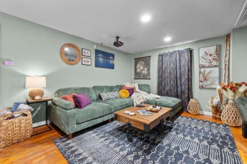 a living room with a green couch and a table at SEMO Redhawks Campus Home with Hot Tub in Cape Girardeau