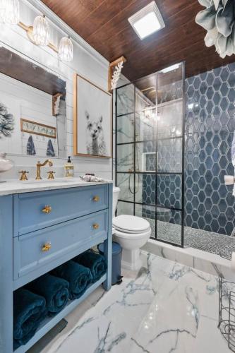 a bathroom with a blue sink and a toilet at SEMO Redhawks Campus Home with Hot Tub in Cape Girardeau