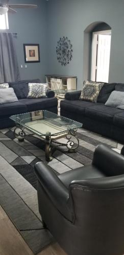 a living room with two couches and a glass table at Mufasa's Pride in Kissimmee