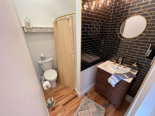 a bathroom with a sink and a toilet and a mirror at The Mediterranean House - Beautiful Downtown House in Perryville