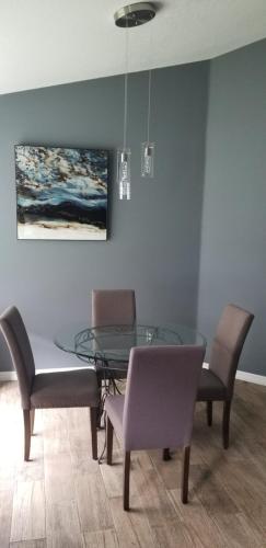 a dining room with a glass table and chairs at Mufasa's Pride in Kissimmee