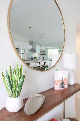 a mirror on a wall above a table with a plant at Summer fun in Indian Wells. Private Pool, 4BD, 3BA. in Indian Wells