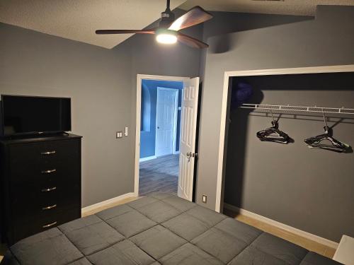 a bedroom with a bed and a ceiling fan at Mufasa's Pride in Kissimmee