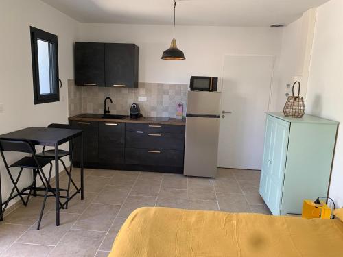 Il comprend une cuisine équipée d'une petite table et d'un réfrigérateur. dans l'établissement Studio la salicorne, à Sérignan