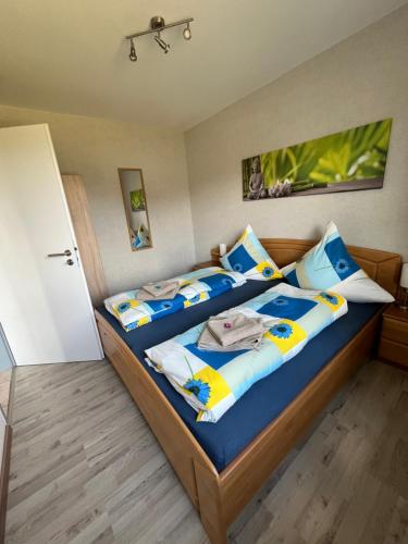 a bedroom with two beds with blue and yellow pillows at Ferienwohnung - Monteurwohnung Büren in Büren