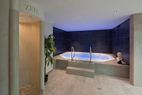 a large bathroom with a tub in a room at Hotel Matterhornblick in Zermatt