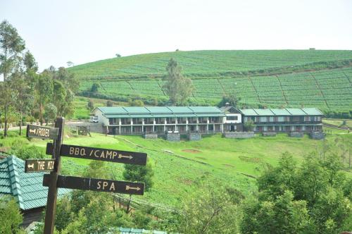 a building on a hill with street signs in front at Destiny - The Farm Resort in Ooty