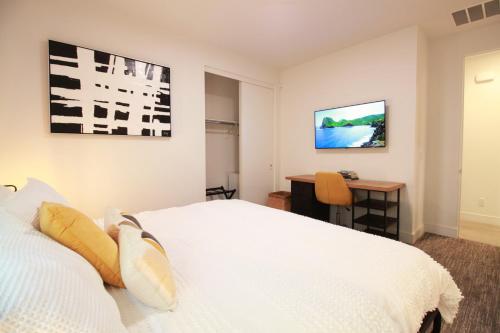 a bedroom with a white bed and a desk at Best Spot in Indian Wells. Walk to Tennis Gardens in Indian Wells