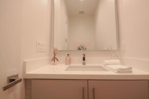 a white bathroom with a sink and a mirror at Best Spot in Indian Wells. Walk to Tennis Gardens in Indian Wells