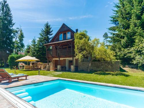 a log house with a pool in front of it at Holiday Home Bila Retreat with Pool by Interhome in Blažejov