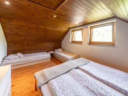 two beds in a room with a wooden ceiling at Holiday Home Bila Retreat with Pool by Interhome in Blažejov