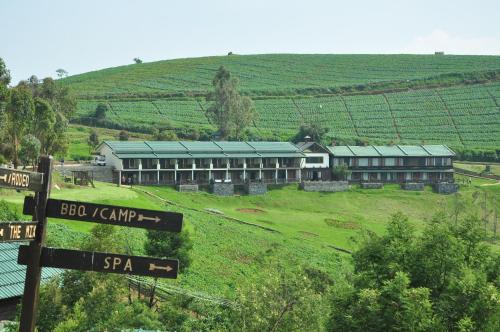 a building on a hill with signs in front of it at Destiny - The Farm Resort in Ooty