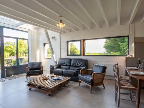 a living room with a couch and chairs and a table at Chalet L'Atelier by Interhome in Locquirec