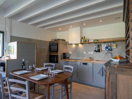 a kitchen with a wooden table and a dining room at Chalet L'Atelier by Interhome in Locquirec