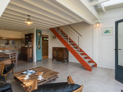 a living room with a staircase and a table at Chalet L'Atelier by Interhome in Locquirec