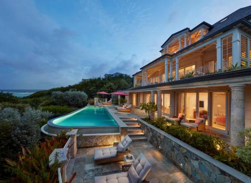an exterior view of a house with a swimming pool at Mandarin Oriental, Canouan in Canouan