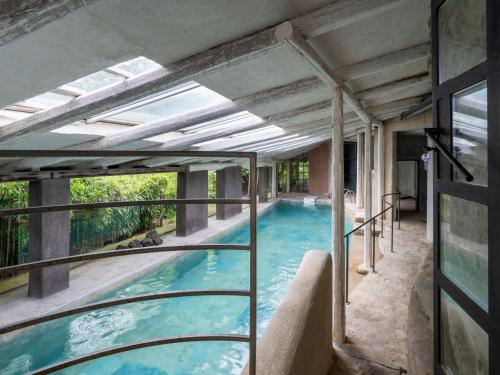 a swimming pool in a building with an open ceiling at Holiday Home Borgo del Riondino by Interhome in Trezzo Tinella